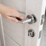 A,Man's,Hand,Opens,An,Interior,Door,With,A,Broken