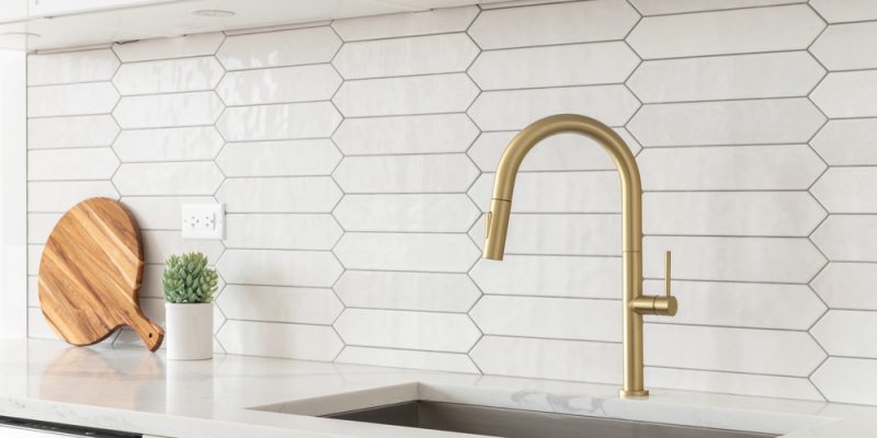 A,Beautiful,Kitchen,Faucet,Detail,With,White,Cabinets,,A,Gold