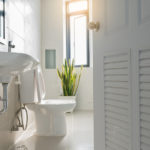 White,Bathroom,Door,That,Overlooks,The,Sink,And,Toilet,Lit